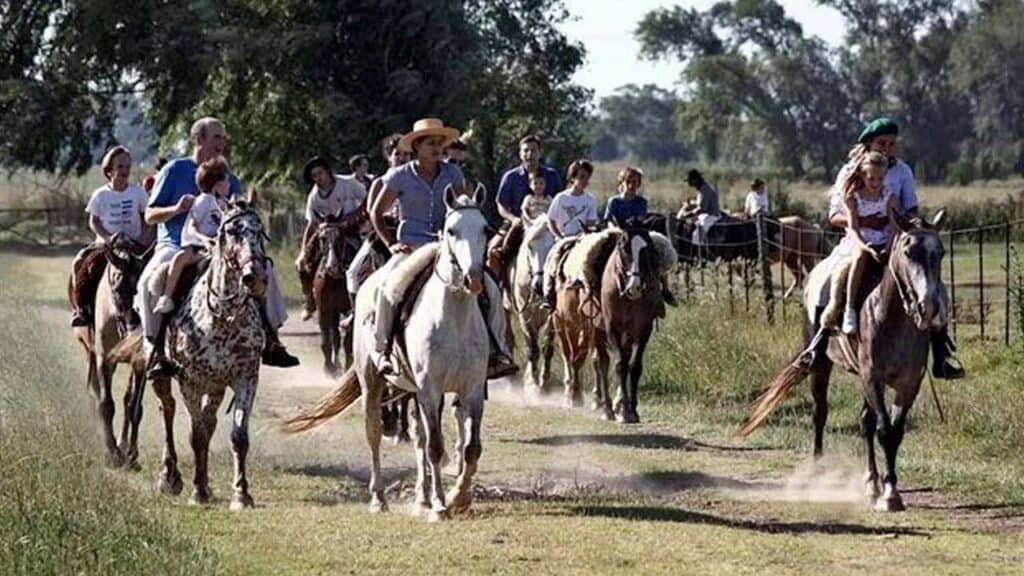 Group of people enjoying horseback riding through lush rural landscape.
