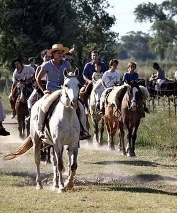 Group of people enjoying horseback riding through lush rural landscape.