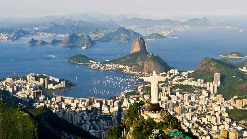 Panoramic view of Rio de Janeiro featuring iconic landmarks and lush green surroundings.