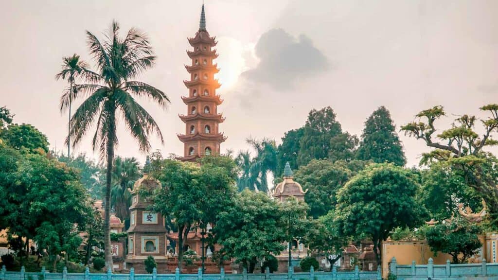 Ancient pagoda with multiple tiers set amidst tropical trees, creating a serene and picturesque scen.