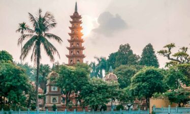Ancient pagoda with multiple tiers set amidst tropical trees, creating a serene and picturesque scen.