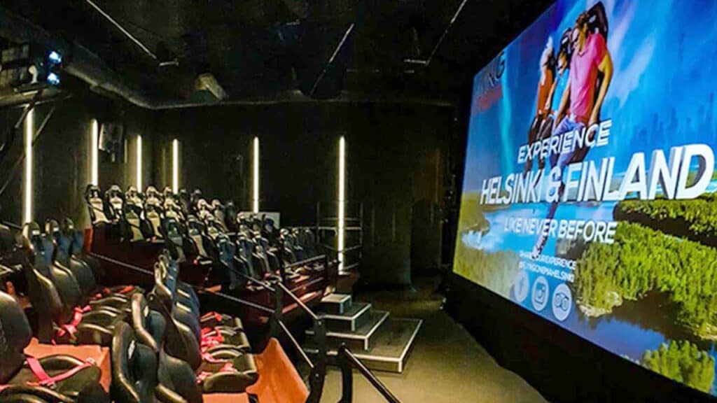 Modern cinema with seats and a large screen displaying Helsinki Finland scenery.