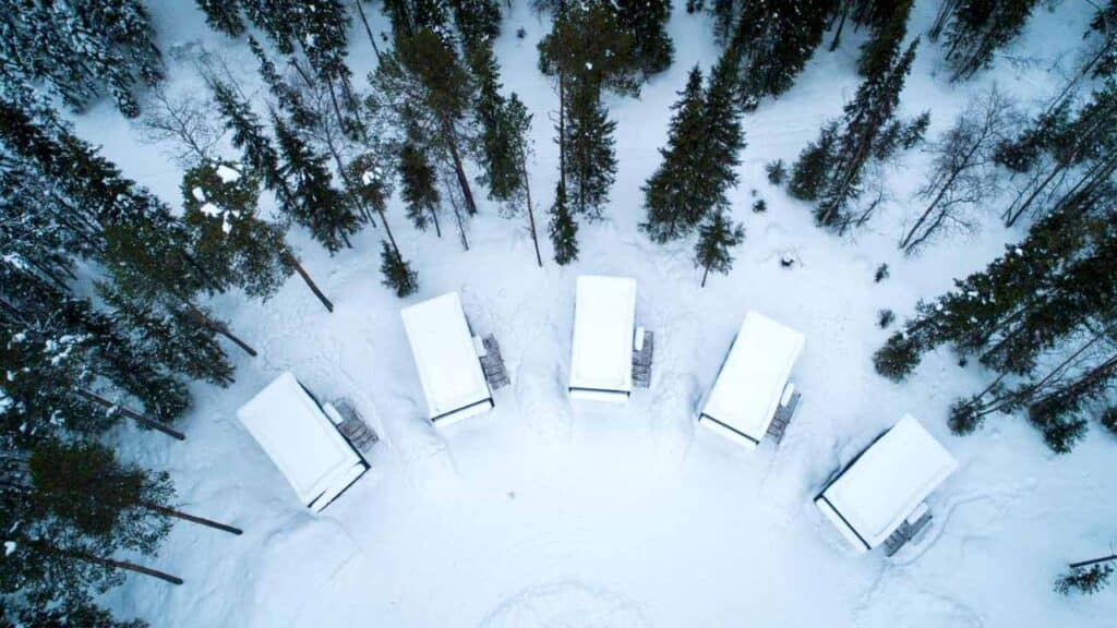 Cozy winter cabins nestled among snow-covered trees, perfect for a holiday getaway with scenic winte.