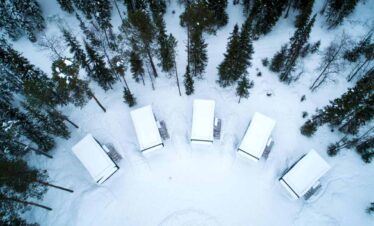 Cozy winter cabins nestled among snow-covered trees, perfect for a holiday getaway with scenic winte.