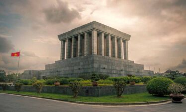 Ho Chi Minh Mausoleum in Hanoi, Vietnam, under cloudy sky.