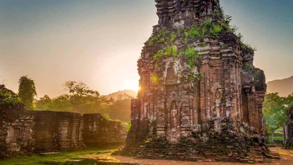 Ancient stone temple with lush greenery at sunset, showcasing historical architecture and serene nat.