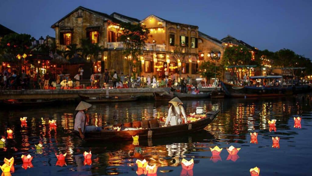Night scene of a lively riverside with boats and illuminated buildings, perfect for travel and holid.