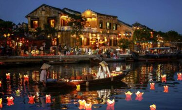 Night scene of a lively riverside with boats and illuminated buildings, perfect for travel and holid.
