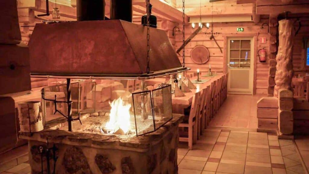 Warm indoor fireplace in a rustic log cabin setting.