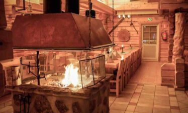 Warm indoor fireplace in a rustic log cabin setting.