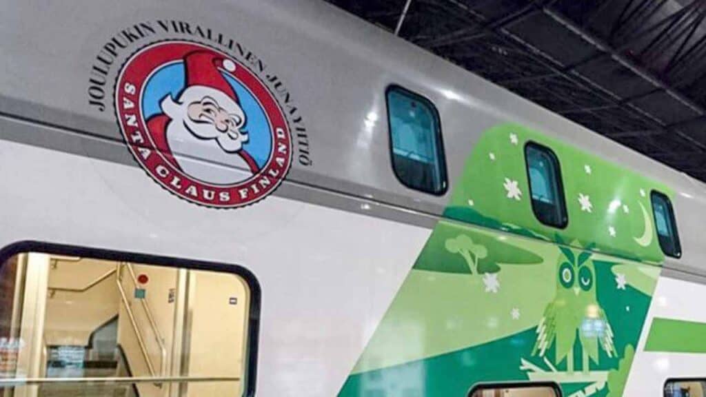 Festive green and white Christmas train with holiday decorations.