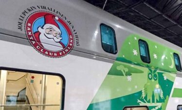 Festive green and white Christmas train with holiday decorations.