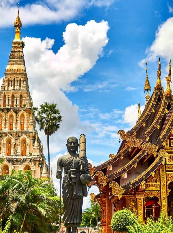 Beautiful Thai temple with intricate architecture and a large Buddha statue in lush surroundings.