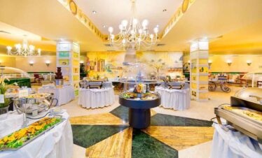 Buffet breakfast with a variety of fresh foods and beverages in a bright, elegant hotel dining area.