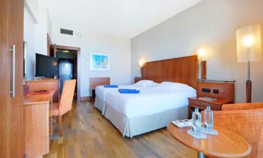 Spacious hotel room with a large bed, modern decor, and amenities for a relaxing stay. Perfect for t.