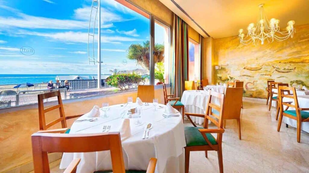 Beachside restaurant with ocean view and elegant interior decor.