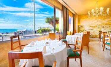 Beachside restaurant with ocean view and elegant interior decor.