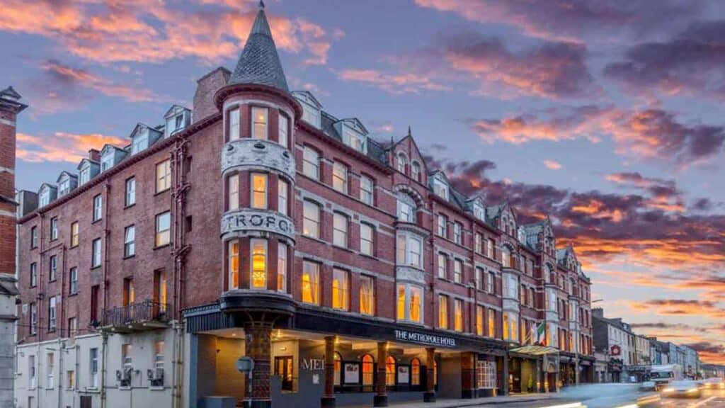 Historic hotel building at sunset with colourful sky in the background.