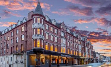 Historic hotel building at sunset with colourful sky in the background.
