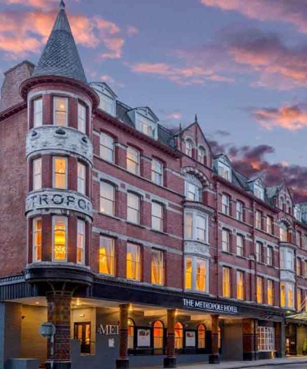 Historic hotel building at sunset with colourful sky in the background.