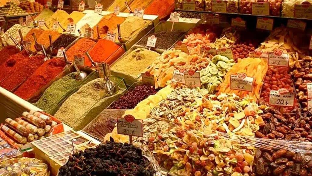 Vibrant display of spices, dried fruits, and herbs at a local market stall.