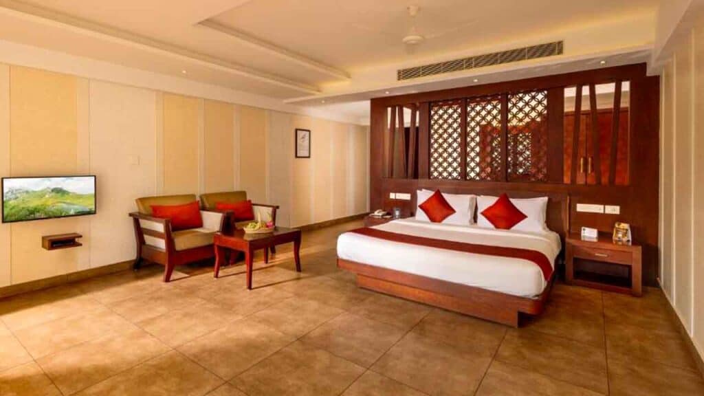 Spacious hotel room with king bed, seating area, and modern decor.