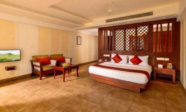 Spacious hotel room with king bed, seating area, and modern decor.
