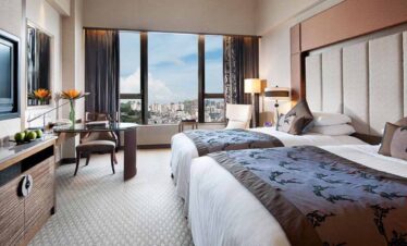 Modern hotel room with city skyline view in Taiwan, Macau, and Hong Kong.