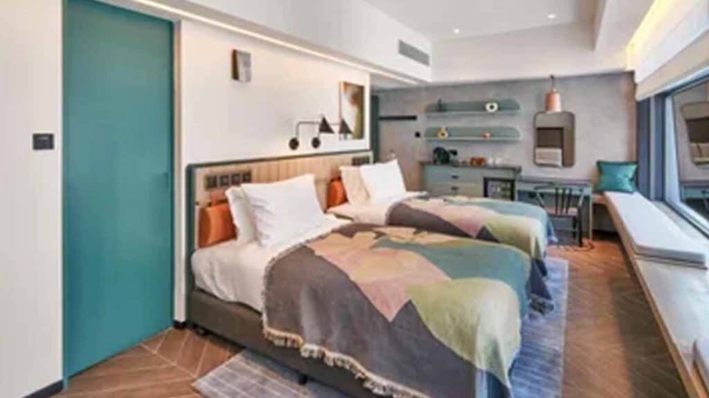 Stylish hotel room featuring two beds, colourful bedding, and contemporary decor for a comfortable s.