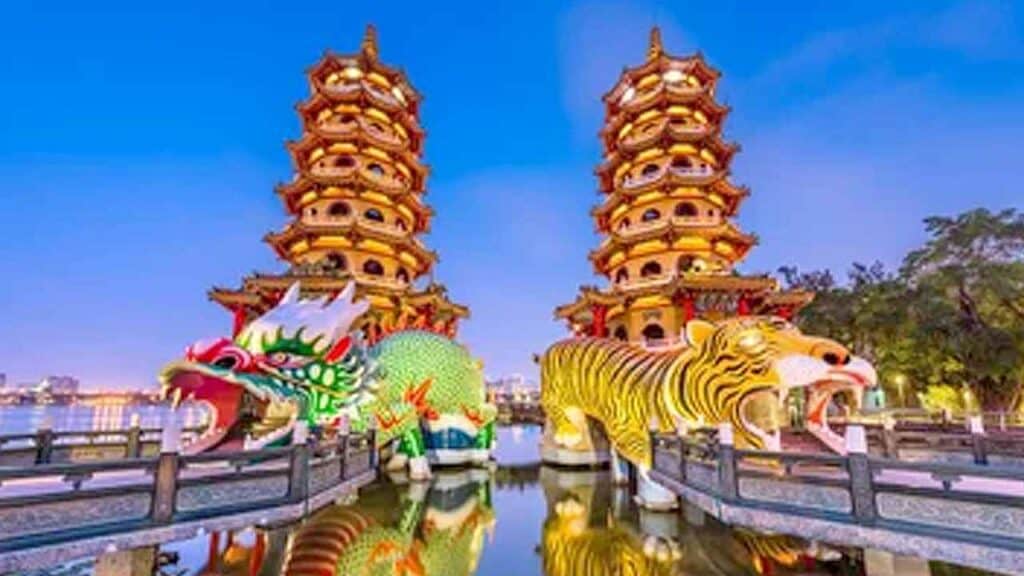 Traditional Chinese pagoda with dragon and tiger statues at a scenic park.