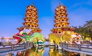 Traditional Chinese pagoda with dragon and tiger statues at a scenic park.