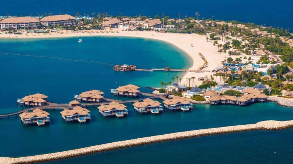 Overwater bungalows at a tropical resort with clear blue waters.