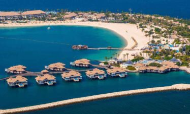 Overwater bungalows at a tropical resort with clear blue waters.