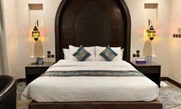 Luxurious hotel bedroom with elegant decor and plush bedding.