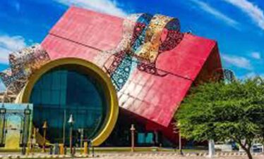 Modern colourful building with circular entrance and unique architecture.