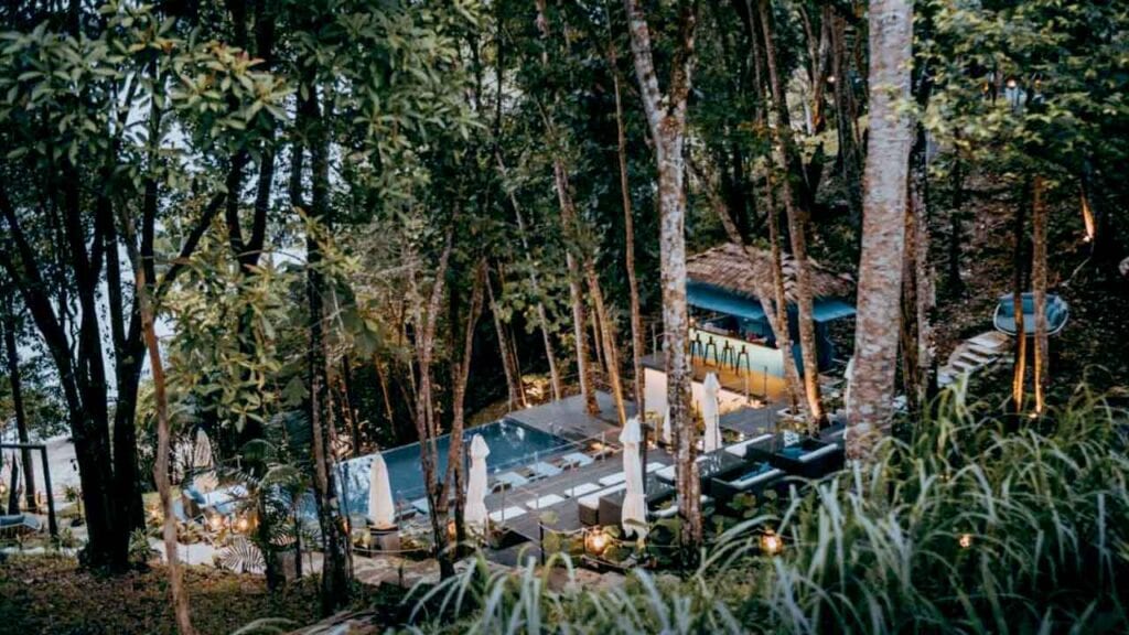 Secluded tropical forest retreat with pool and outdoor seating area.