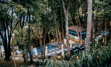 Secluded tropical forest retreat with pool and outdoor seating area.