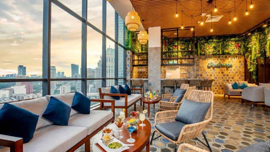 Cozy lounge area with large windows overlooking the city skyline, stylish furniture, and warm lighti.