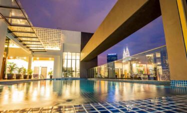 Rooftop pool overlooking city skyline with Empire State Building in the background.