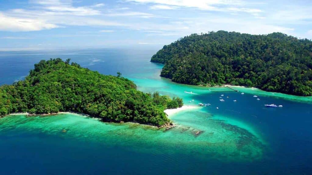 Aerial view of lush green islands surrounded by turquoise waters and white sandy beaches.