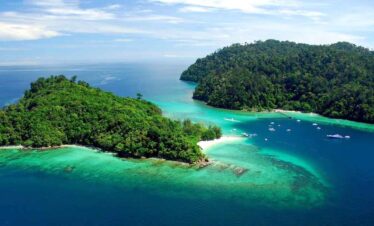 Aerial view of lush green islands surrounded by turquoise waters and white sandy beaches.