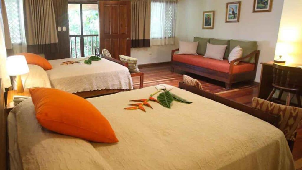 Comfortable hotel room with two beds and garden view in a tropical setting.