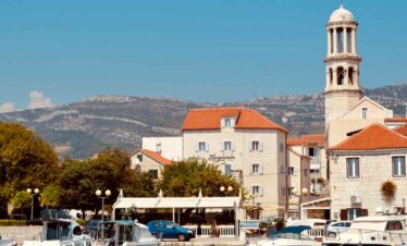 Beautiful coastal town with historic buildings and a church tower, perfect for holiday adventures.
