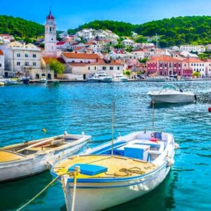 Harbour with boats and colourful seaside town in the background.