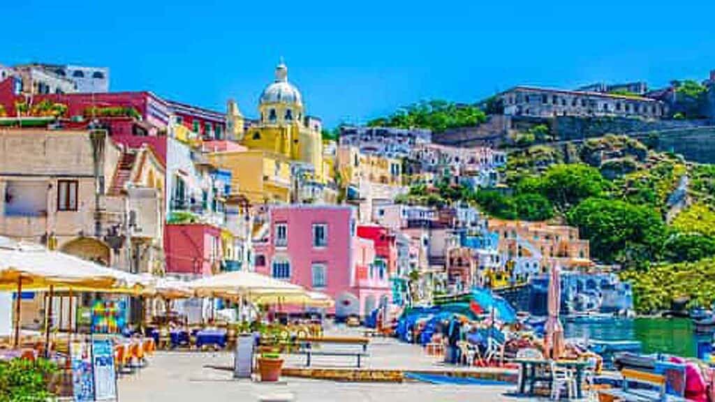 Colourful Mediterranean coastal village with pastel buildings and seaside cafes.