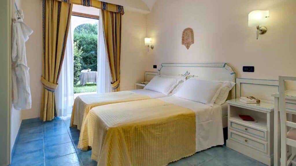 Comfortable hotel bedroom with garden view and bright decor.