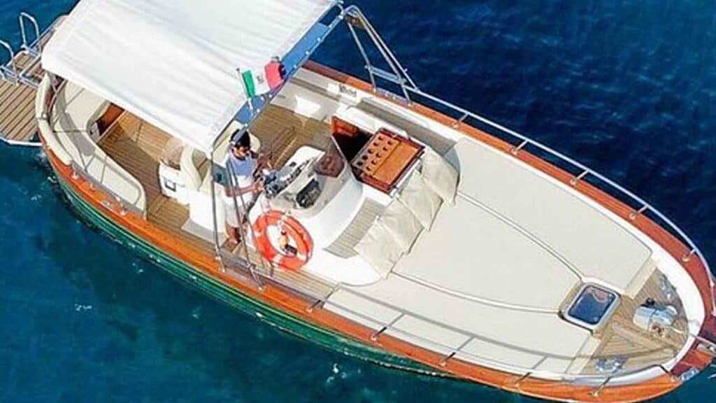 Luxury yacht cruising on clear blue waters with crew onboard.