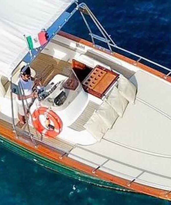 Luxury yacht cruising on clear blue waters with crew onboard.