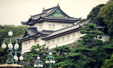 Traditional Japanese castle with ornate roof design and lush greenery.