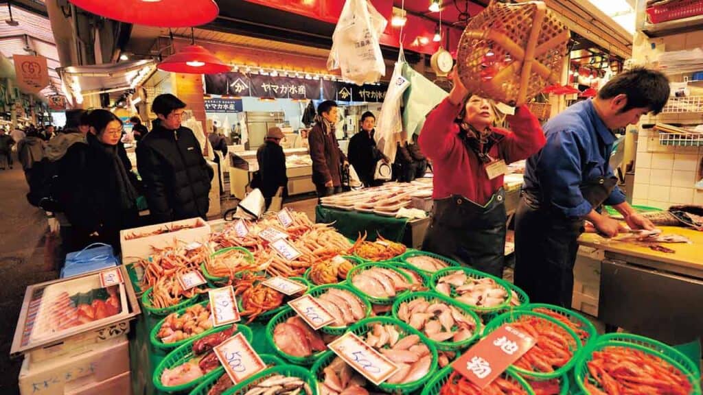 Vibrant seafood stall with fresh fish and shellfish at a lively night market.